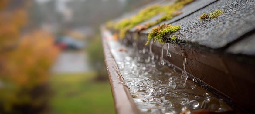 replace your gutters. Clogged seamless gutters overflowing with rainwater, showing why gutters matter and when gutter replacement is needed